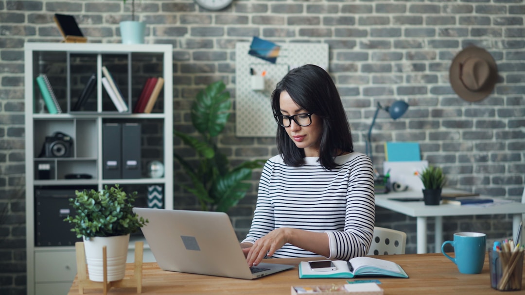 A woman efficiently organizes and manages digital documents on her laptop with the help of modern fax services.