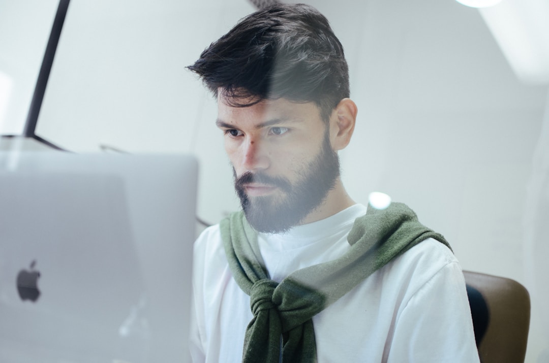 A man working on his computer to increase productivity through seamless fax integration, efficiently managing tasks and documents.